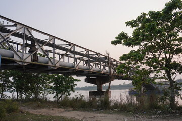Fototapeta premium Giant pipes inside the pipeline bridge, several trees are growing there