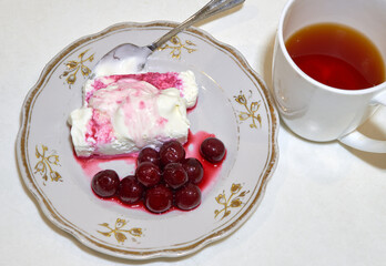 cottage cheese with cherries and tea lie on the kitchen table