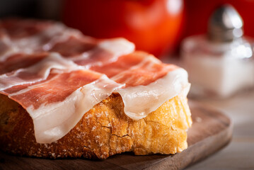 Close-up of bacon and ham on a slice of toasted bread, typical breakfast of Andalusia.