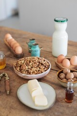 A vintage nutcracker splits walnuts on a weathered wooden countertop. Surrounding it are farm-fresh...