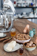 In a cozy farmhouse kitchen, a vintage nutcracker cracks open natural walnuts on a weathered wooden counter, surrounded by fresh ingredients for a delightful baking session