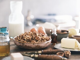 A vintage nutcracker is at work gently splitting walnuts on a wooden countertop in a rustic...