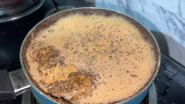 Chai tea boiling in pan. Making tea with milk in pan. Masala chai tea boiling in a pot.