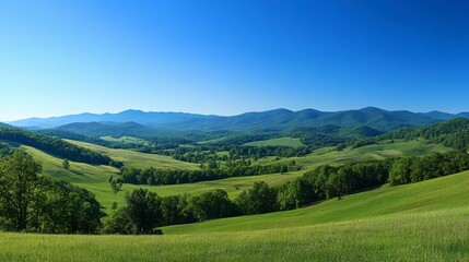 Fototapeta premium Serene Panoramic View of a Lush Green Valley and Distant Mountains Under a Clear Blue Sky