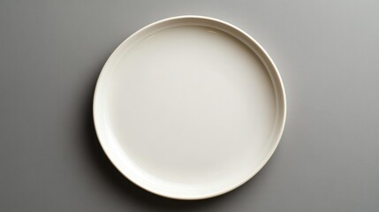 Minimalist top view of an elegant round ceramic plate with a glossy finish on a neutral gray background. Perfect for branding, menu design, food photography samples, and product presentations.