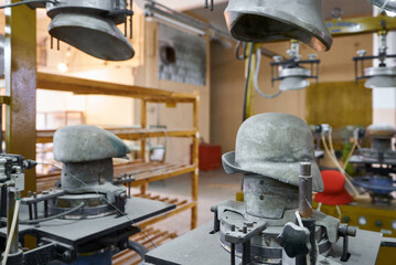 Crafting beautiful felt hats in a charming workshop filled with unique molds and artisanal tools that showcase the art of hat making