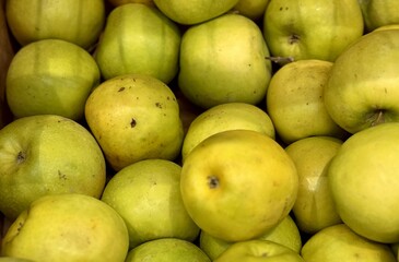 A mound of large green coloured apples in boxes is displayed in the window of the supermarket's vegetable stand, demonstrating organic, vegetarian and healthy food. Close-up