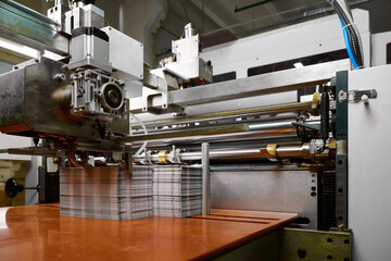 Glue spreading machine operates efficiently as paper feeds through for precise adhesion in a modern production facility