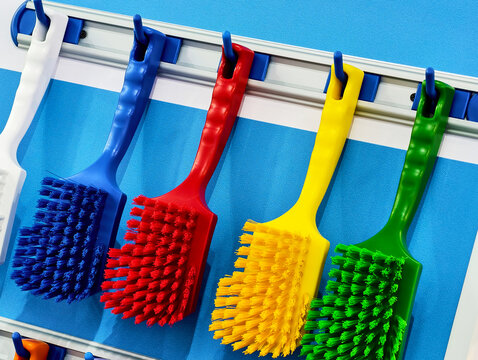 Vibrant collection of cleaning brushes hanging on a display in a bright workspace ready for organization and tidiness