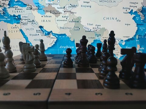 Geopolitical Strategy Concept. Chess, Strategy game with pieces on chessboard and world map in background