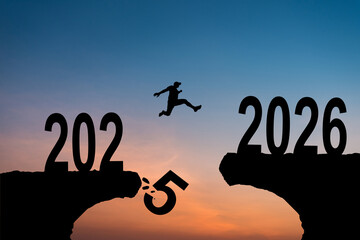New Year 2026, Inspiration and progress towards new success. Silhouettes of human jumping over cliff towards finish line with text new year 2026 on sunset beautiful