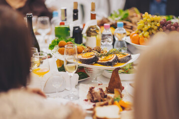 A sumptuous banquet table features an array of colorful dishes, including seafood and fruits, alongside beverages during a lavish event. Guests enjoy the festivities in a refined atmosphere