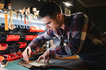 Portrait of handsome tanner man at work, small business, authentic workshop, indoors. leather goods.