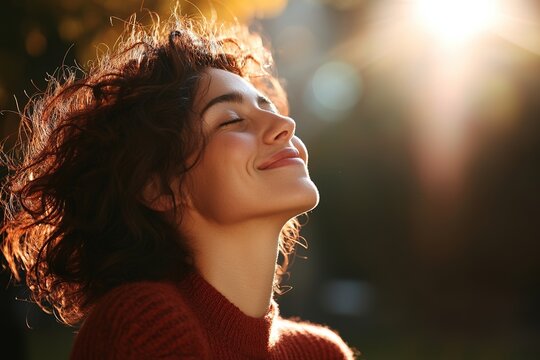 A woman dressed in red is inhaling the crisp air of autumn surrounded by trees in a forest