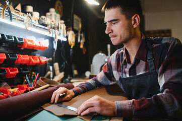 Banner tailor industry craftsman. Leather rolls and tools for handmade craft in workshop
