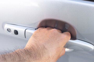 自動車のドアを開ける男性の手