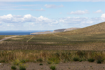Naklejka premium Landscape composed of extensive green fields and hills by the sea