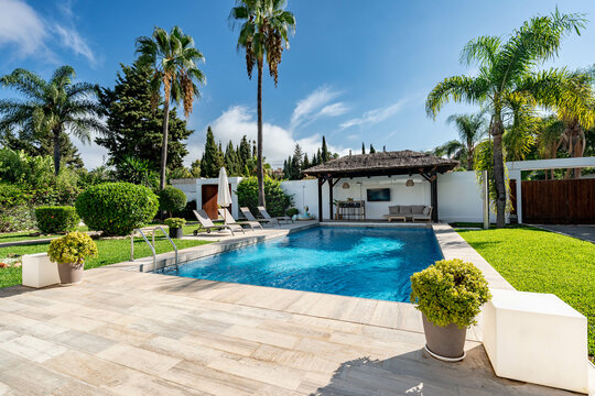 an image of a luxury mediterranean garden with private swimming pool and poolside bar 