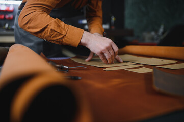 leather craftsman is carefully to make a leather product for a customer. Leather craftsman concept