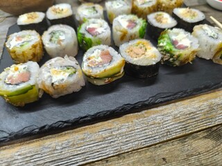 Close-up of various sushi lying on a granite board
