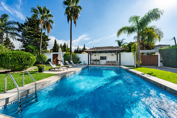 an image of a private swimming pool with poolside bar and sun loungers in mediterranean villa 