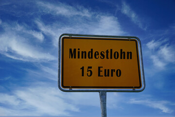 Schild mit der Aufschrift Mindestlohn 15 Euro - wird er Mindestlohn in Deutschland erhöht