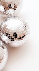 Reflective disco ball trio capturing light on white background