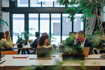 Diverse businesspeople working in modern green office space © bernardbodo