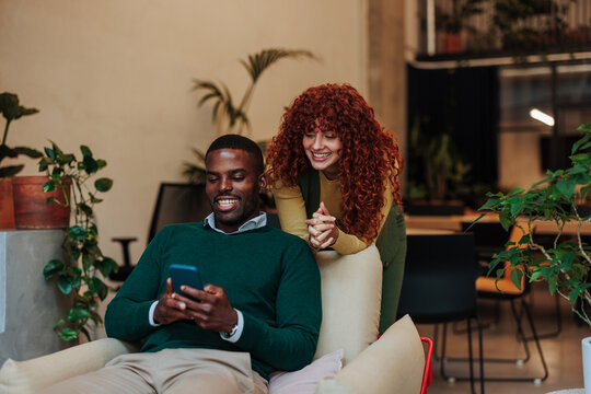 Smiling colleagues sharing a moment of levity in modern office space