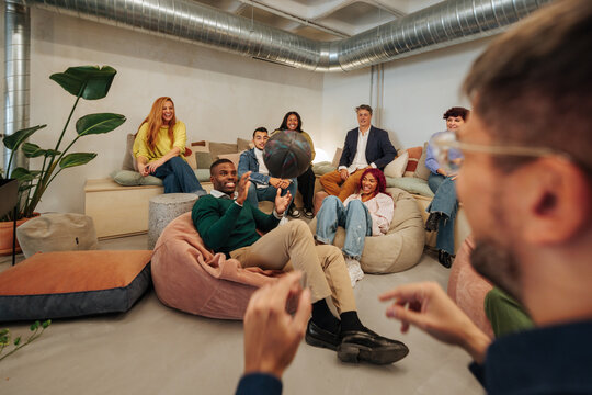 Diverse business team playing with basketball during break time in modern office - Powered by Adobe