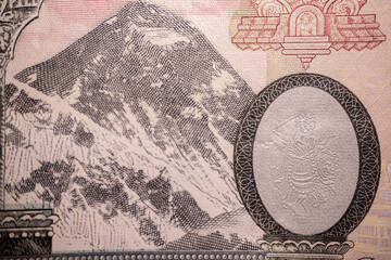 A macro shot of a Nepalese rupees 1000 banknote featuring intricate details, including an elephant, security emblem, and traditional design elements. The note's texture and fine print are highlighted.