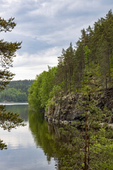 A beautiful lake surrounded by trees and a cloudy sky