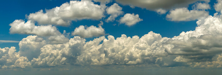Blue sky with white summer rain clouds. Colorful summer landscape