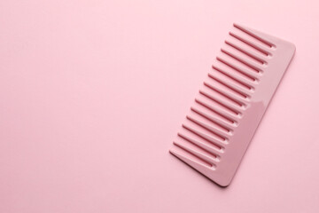 One plastic hair comb on pink background, top view. Space for text