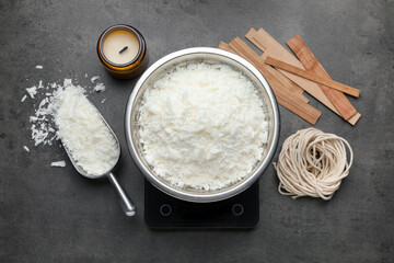 Soy wax and other supplies for making candles on grey table, flat lay