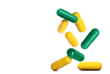 Many different pills falling on white background