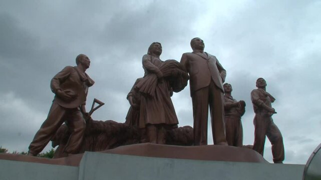 Statues with smiling Kim Il Sung  and peasants, Pyongyang, North Korea