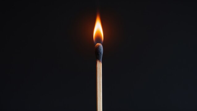Lighting matches at the instant of explosion. Burning wooden match against a black backdrop. Close-up view.