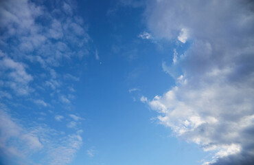 A panoramic view of a blue sky with fluffy white clouds, creating an atmosphere of serenity and lightness. Symbolizes freedom, dreams, and tranquility.