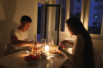 Couple enjoying romantic candlelit dinner at home