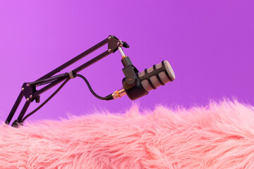 Microphone on a pink fuzzy surface ready for an engaging podcast recording session