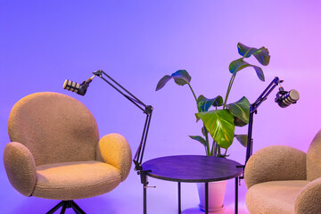 Podcast setup with cozy chairs and high-quality microphones in a vibrant studio space