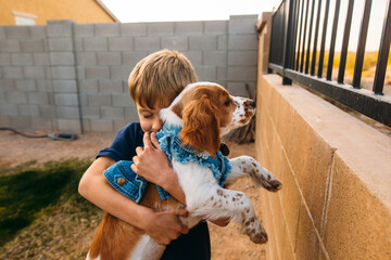 Boy holding his dog in the backyard