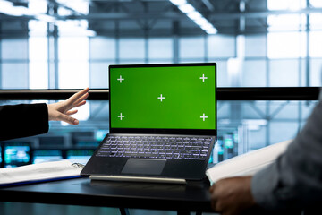 Teamworking technicians in data center use mockup notebook, observing analytics, reviewing equipment health. Server room IT experts using isolated screen laptop, adjusting system parameters, close up