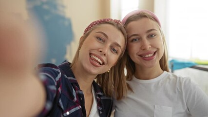 Women taking a selfie together in a cozy living room environment at home, showcasing their familial bond, blonde hair, and casual attire with modern apartment decor in the background. - Powered by Adobe