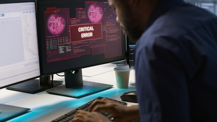 Programmer seeing red critical error popup on computer display in data center, panicking. African...