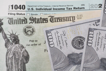 Prop US currency and treasury department check and top of 1040 tax form