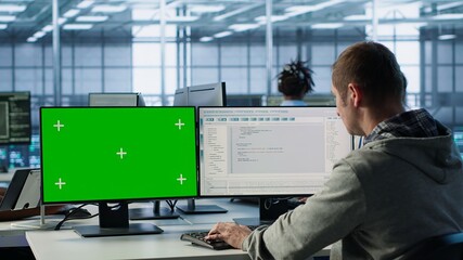 Software developer using green screen PC to do programming in server room providing computing resources for workloads. IT expert supervising data center supercomputers using mockup computer, camera A