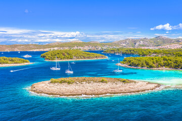 A breathtaking aerial view of the Pakleni Islands, Hvar, featuring the secluded Mlini Beach, surrounded by lush Mediterranean nature, making it a top sailing and summer getaway destination