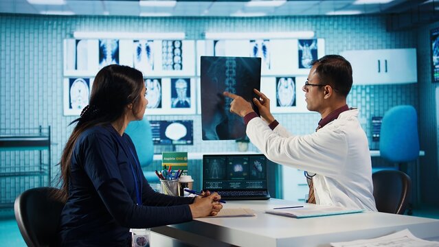 Indian general practitioner and patient engage in a medical consultation with diagnostic tools and x ray text results for scan interpretation. Showcasing healthcare practices and research. Camera B.